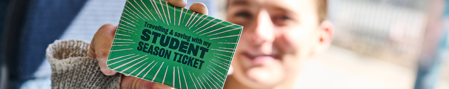 student holding a student season ticket in frame