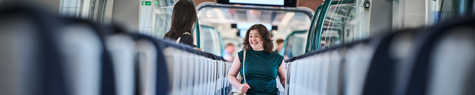 Student walking through London Northwestern Railway train carriage