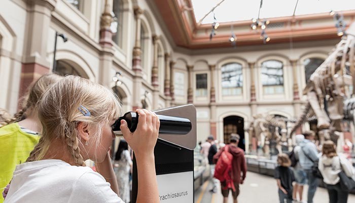 Child looking viewing into telescope at a Museum