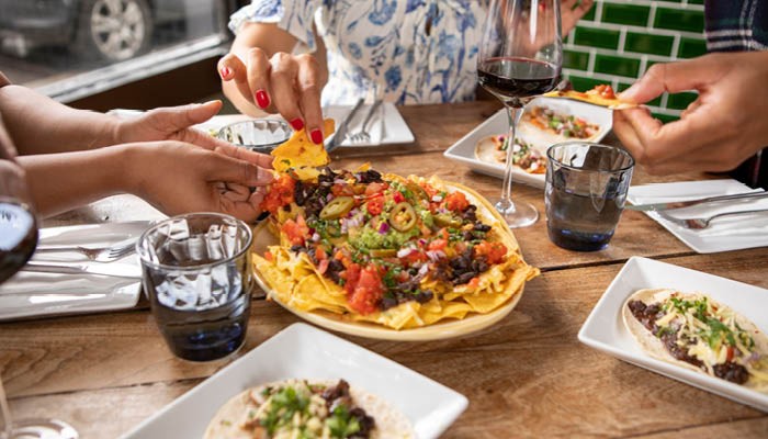 Close up of friends enjoying Mexican food at restaurant table