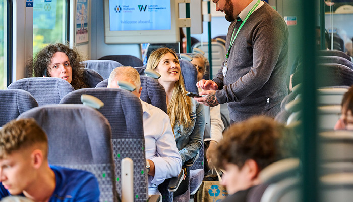 passengers on train with conductor