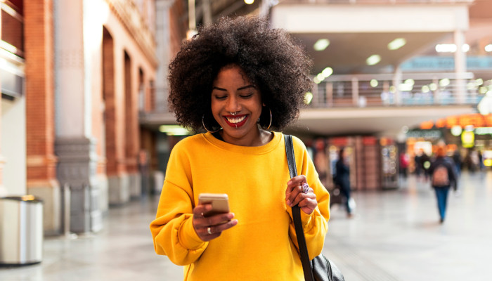 person looking at their phone at a train station