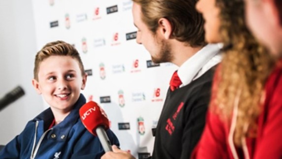A young biy in Liverpool's press conference room.