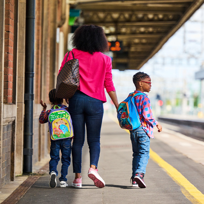 Parent and two children on station platform