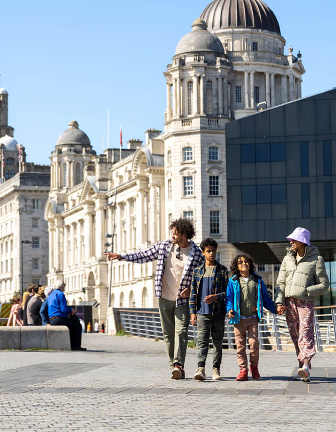 people walking in liverpool with historic building in the background