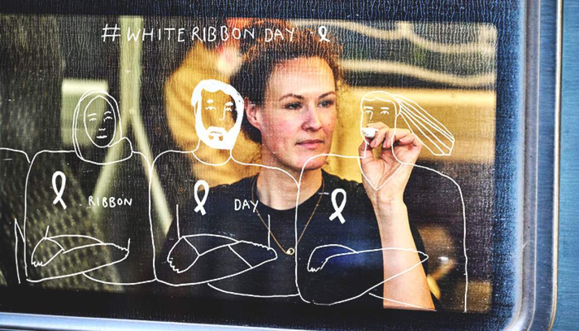 person drawing white ribbon illustrations on a train window