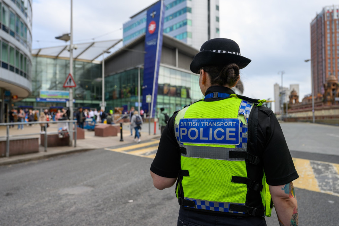 Female BTP officer patrolling outside a station